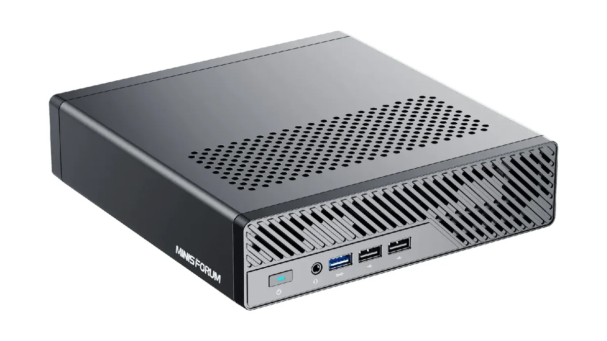 Minisforum MS-01 vu de trois quarts, avec son boîtier plat, son capot perforé et ses ports USB en façade