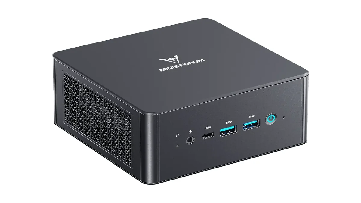 Minisforum UM890 Pro gris vu de trois quarts, avec sa grille latérale et ses ports USB en façade